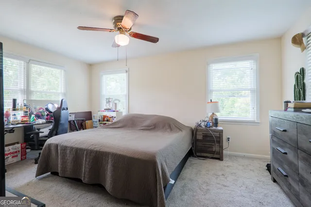 a bedroom with a bed and a table in it with window