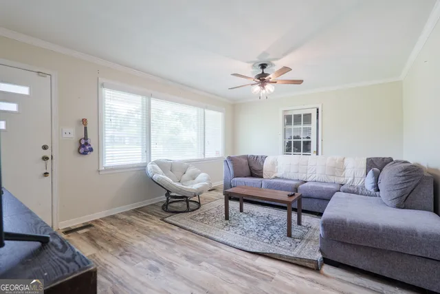 a living room with furniture two windows and a chandelier