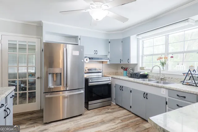 a kitchen with stainless steel appliances a sink cabinets and a window