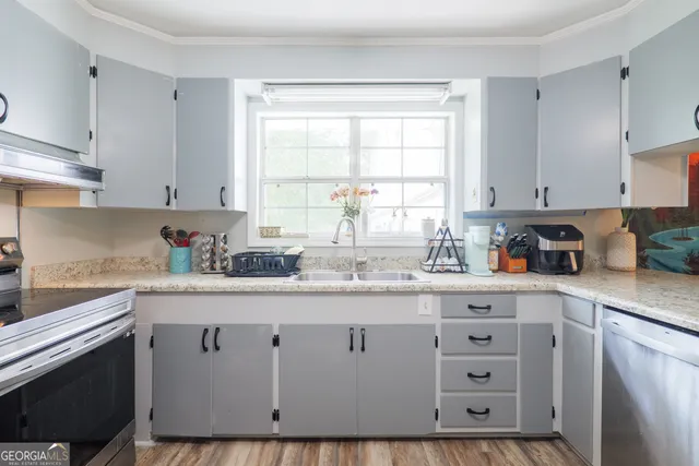 a kitchen with granite countertop a sink white cabinets and window