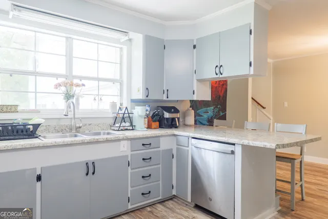 a kitchen with cabinets appliances a sink and a window