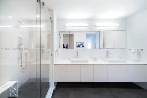 a bathroom with a double vanity sink mirror and shower