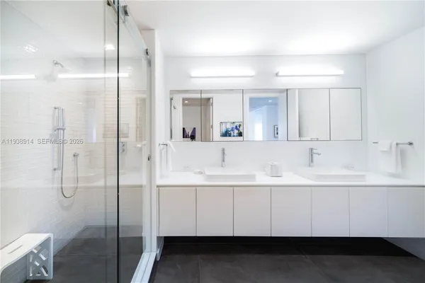 a bathroom with a double vanity sink mirror and shower