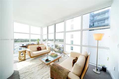 a living room with furniture and a floor to ceiling window