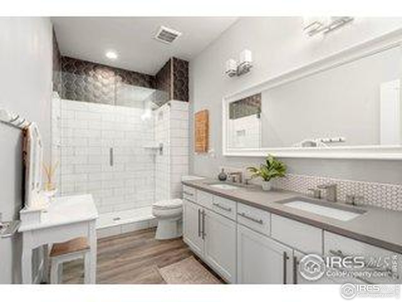 3482 Southeast Frontage Road Fort Collins, CO 80525 - Photo 15 of 47 a bathroom with a granite countertop sink a toilet a mirror a vanity and shower