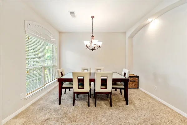 a dining room with furniture a chandelier and a rug