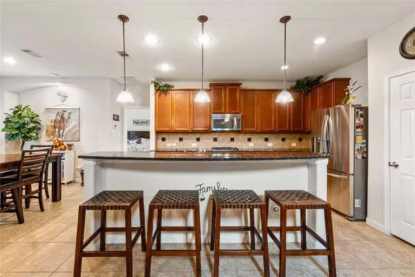 a kitchen with a table chairs refrigerator and microwave
