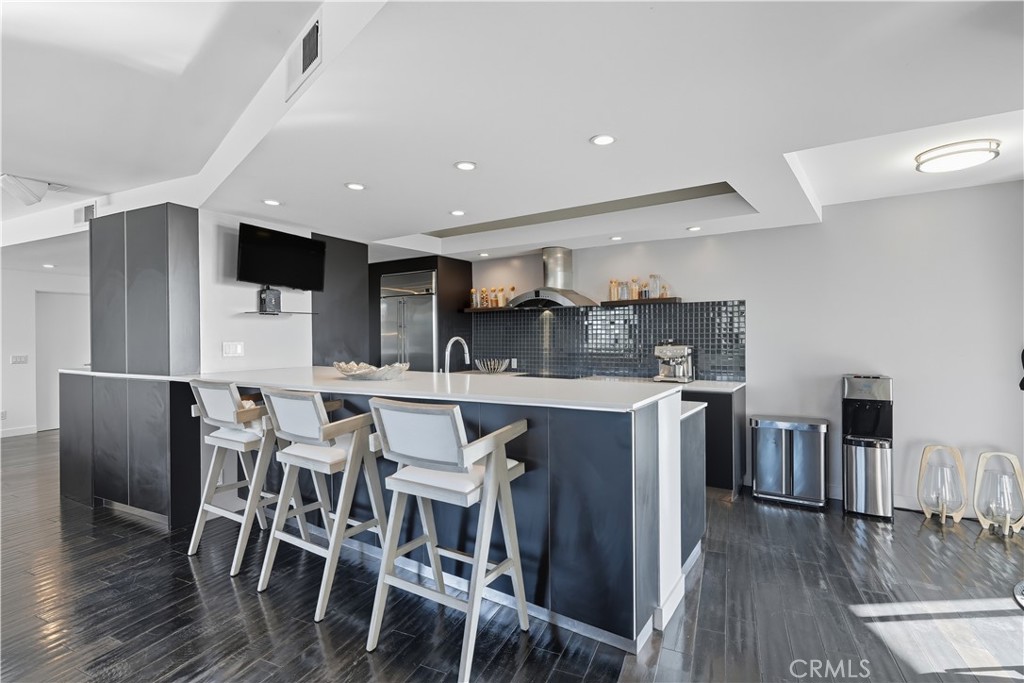 7250 Franklin Avenue, Unit 1203 Los Angeles, CA 90046 - Photo 13 of 37 a kitchen with stainless steel appliances kitchen island granite countertop a table chairs and a refrigerator