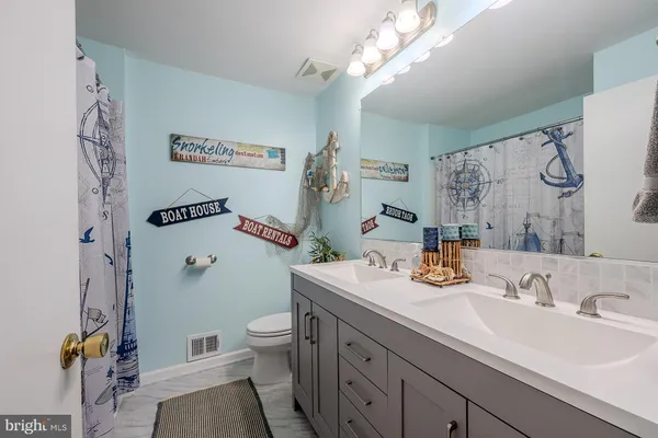 a bathroom with a sink a toilet and a mirror