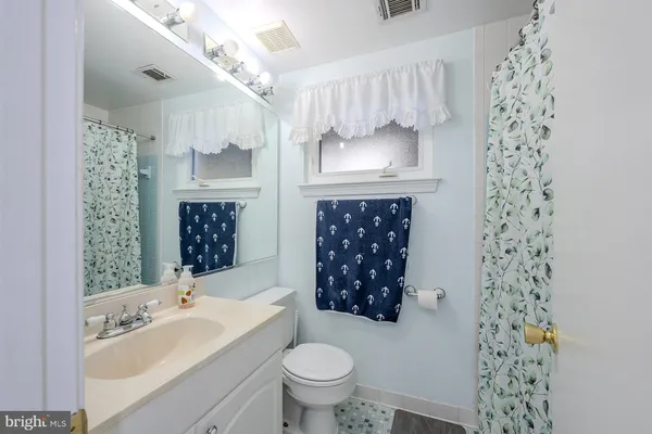 a bathroom with a sink toilet a mirror and shower