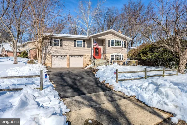 a front view of a house with a yard covered with snow