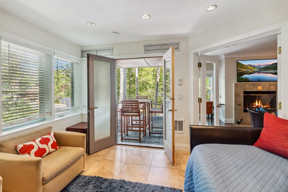 Tiled bedroom featuring access to exterior, french doors, recessed lighting, and a fireplace