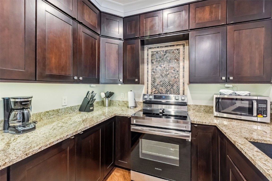 1207 West Keystone Road, Unit 2701 Keystone, CO 80435 - Photo 9 of 41 Kitchen with stainless steel appliances, light stone counters, and dark brown cabinetry
