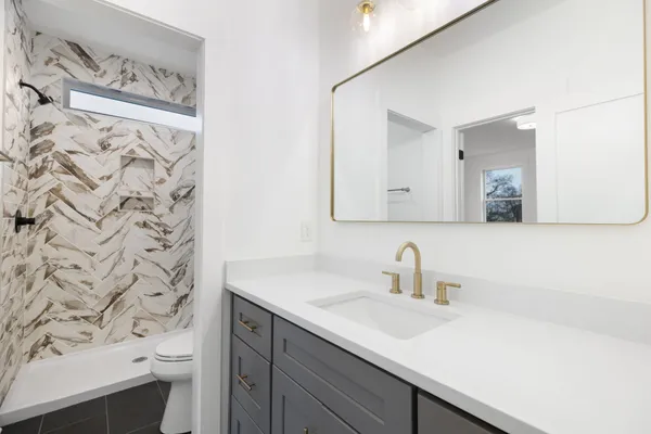 a bathroom with a sink a toilet and a mirror