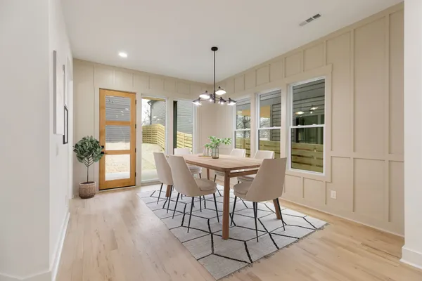 a dining room with furniture window and wooden floor