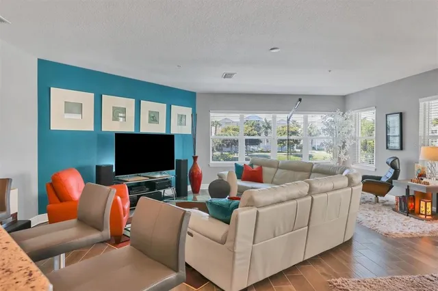 a living room with furniture a large window and a flat screen tv