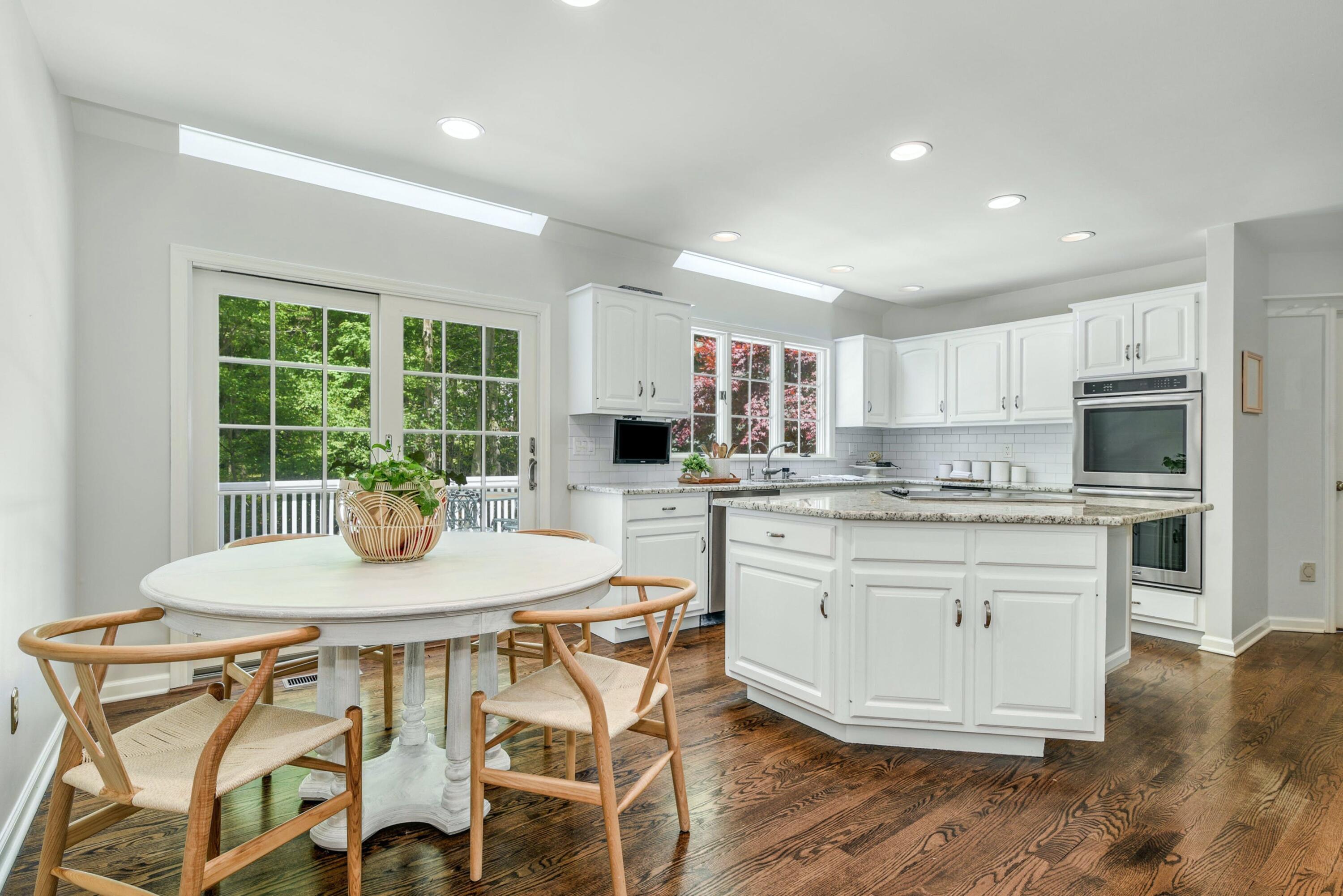 220 Old Norwalk Road New Canaan, CT 06840 - Photo 20 of 36 a kitchen with stainless steel appliances granite countertop a stove a refrigerator a sink dishwasher a dining table and chairs with wooden floor