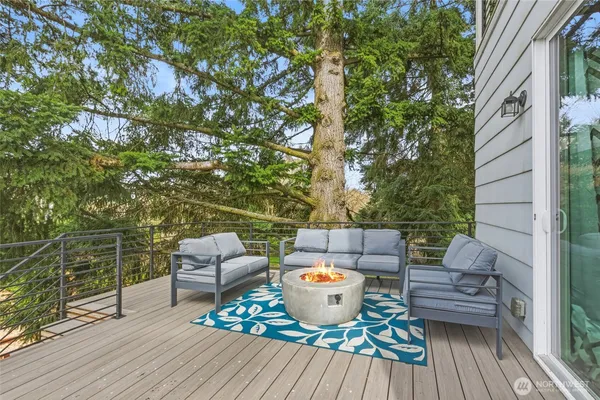 a view of a backyard with table and chairs and couches under an umbrella