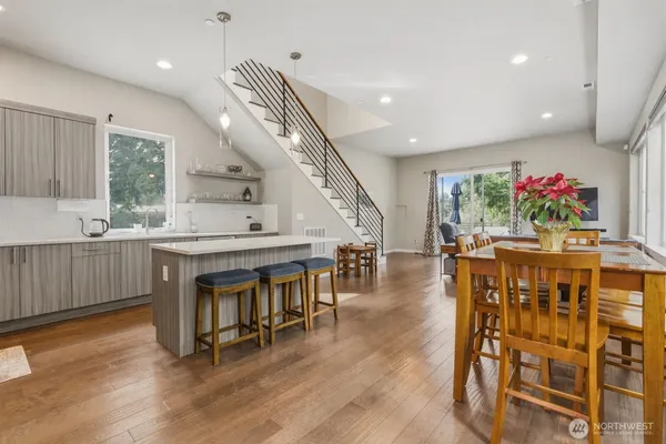 a kitchen with kitchen island a stove a table and chairs in it