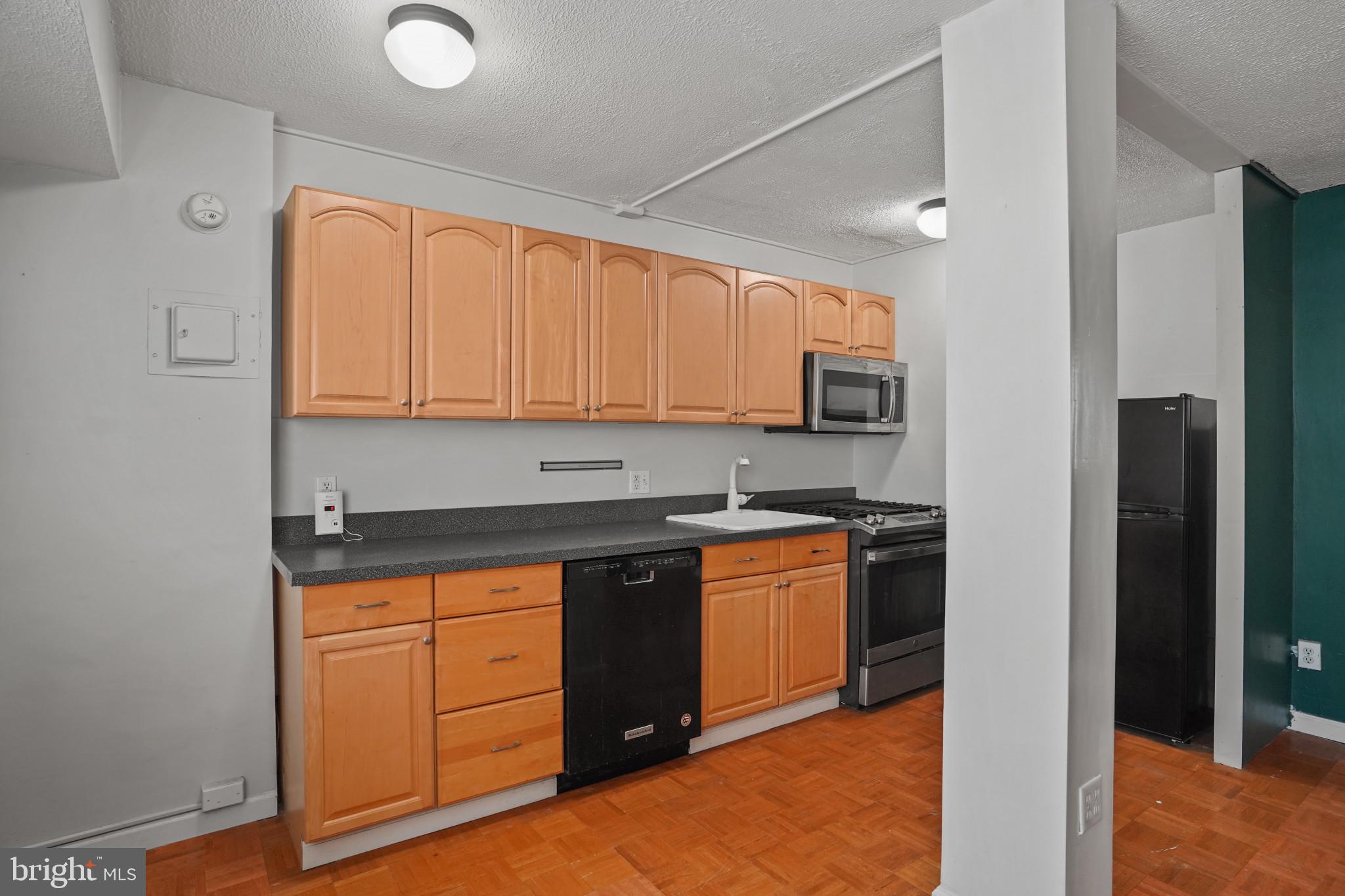 1801 Clydesdale Place Northwest, Unit 420 Washington, DC 20009 - Photo 12 of 33 a kitchen with stainless steel appliances granite countertop a stove a sink and a refrigerator