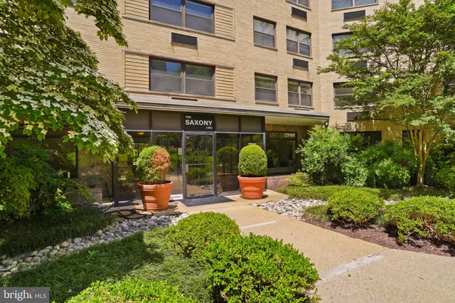 a view of a building with sitting area and garden