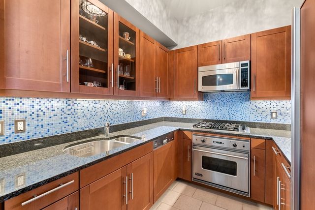 a kitchen with granite countertop cabinets stainless steel appliances and a sink