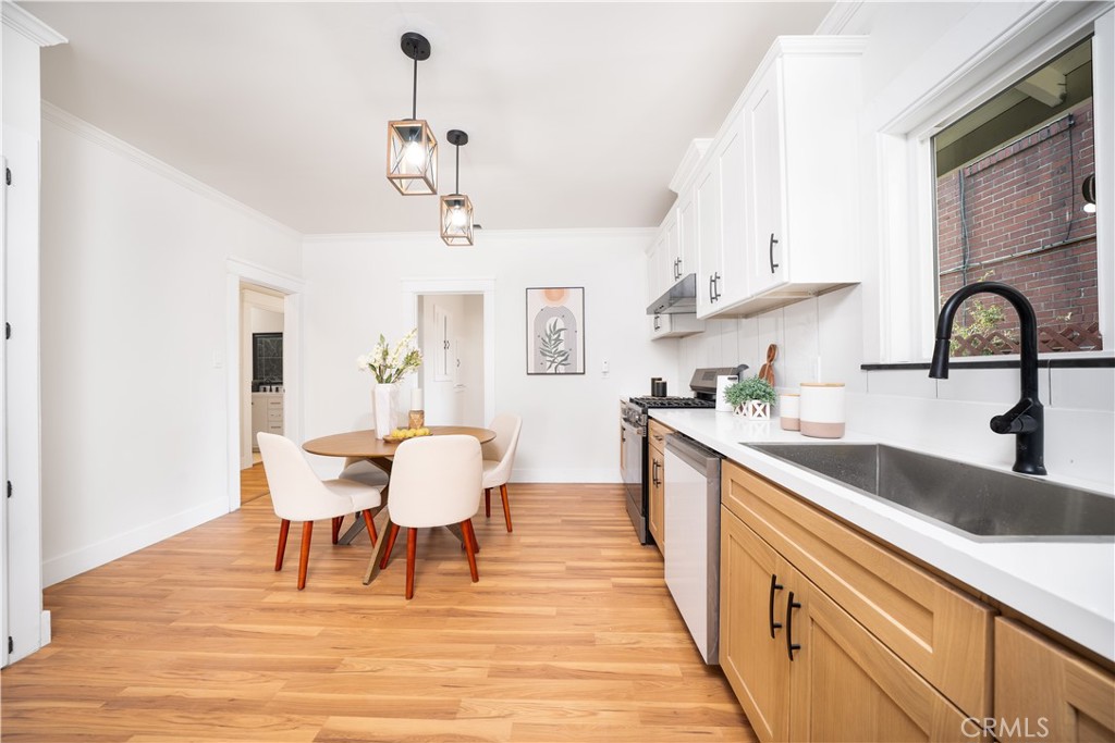 843 Cedar Avenue Long Beach, CA 90813 - Photo 12 of 42 a kitchen with stainless steel appliances granite countertop a dining table chairs a sink and dishwasher a refrigerator with wooden floor