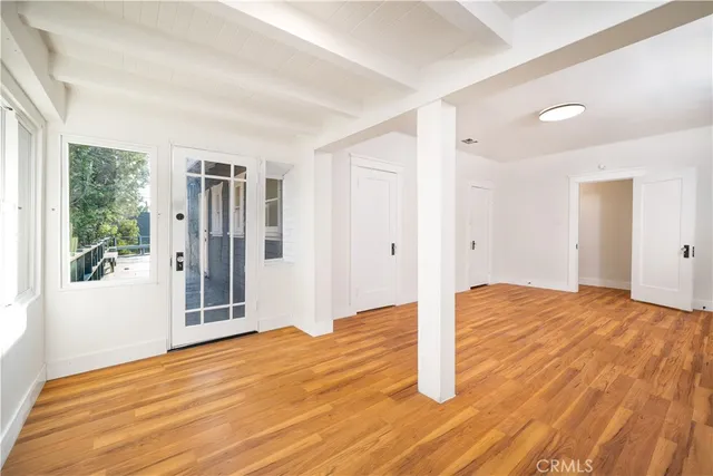 a view of empty room with wooden floor and fan
