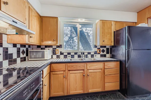 a kitchen with stainless steel appliances granite countertop a sink and a refrigerator
