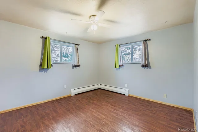 a view of empty room with wooden floor
