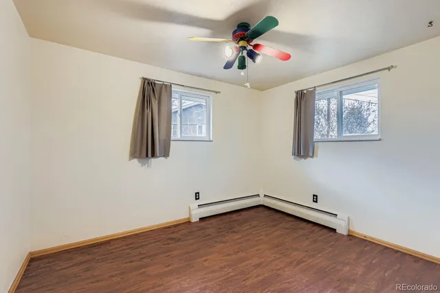 a view of empty room with wooden floor