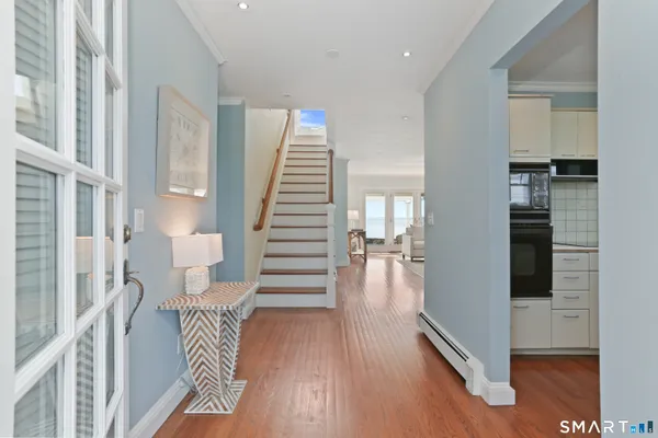 a view of entryway and hall with wooden floor