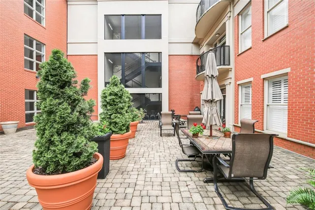 a view of a patio with table and chairs potted plants