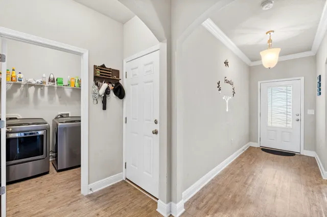 a kitchen with stainless steel appliances granite countertop a refrigerator a stove a sink a dining table and chairs