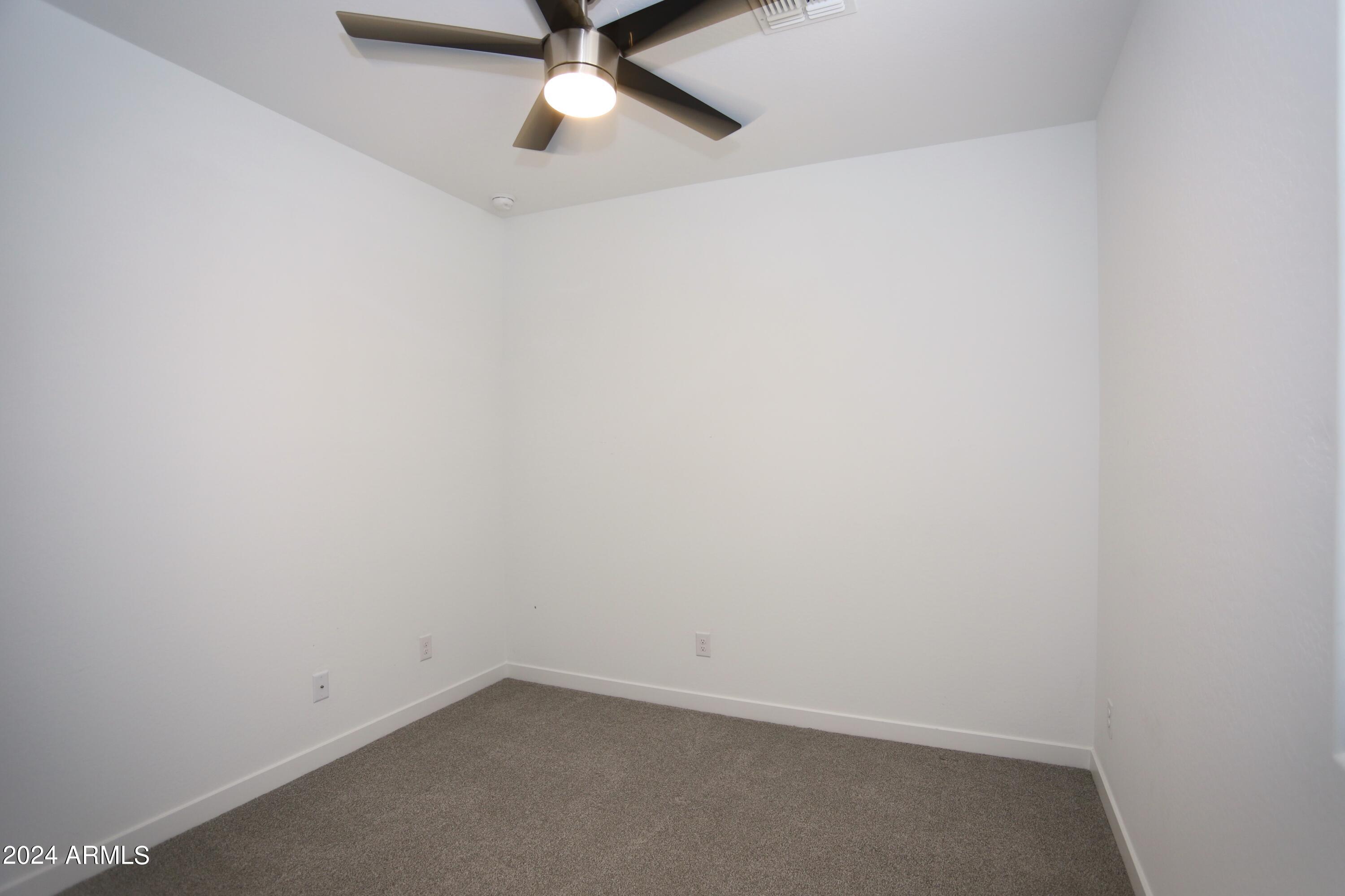 1651 West Piedmont Road Phoenix, AZ 85041 - Photo 11 of 46 an empty room with a window and a fan