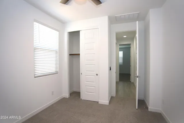 an empty room with windows and closet