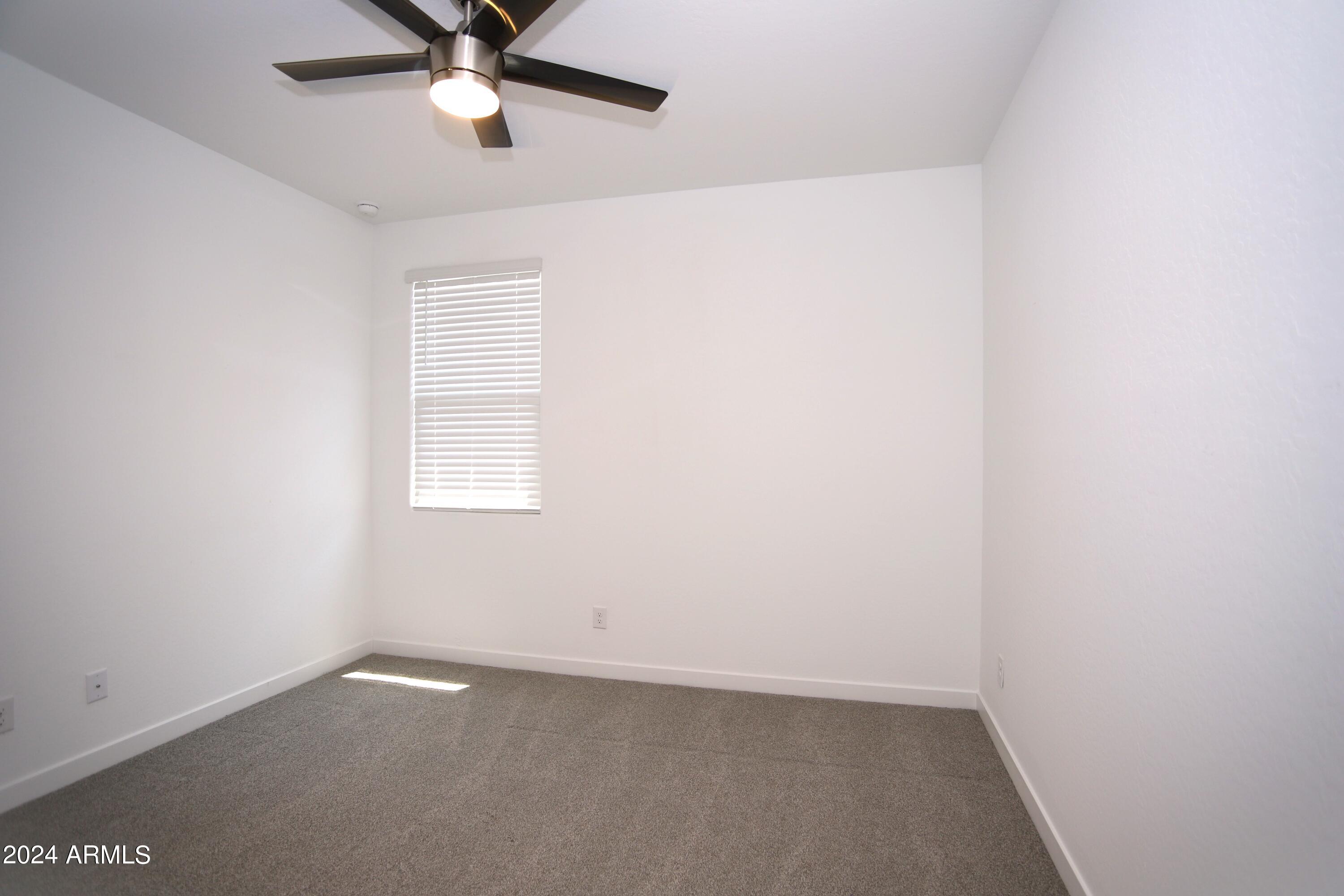 1651 West Piedmont Road Phoenix, AZ 85041 - Photo 13 of 46 an empty room with a window and a fan