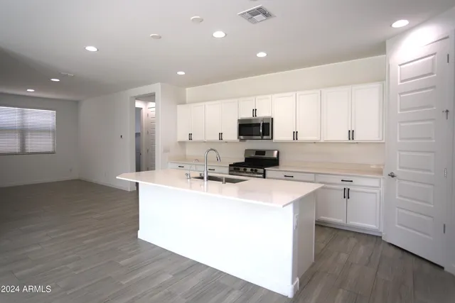 a kitchen with appliances a sink a counter space and cabinets