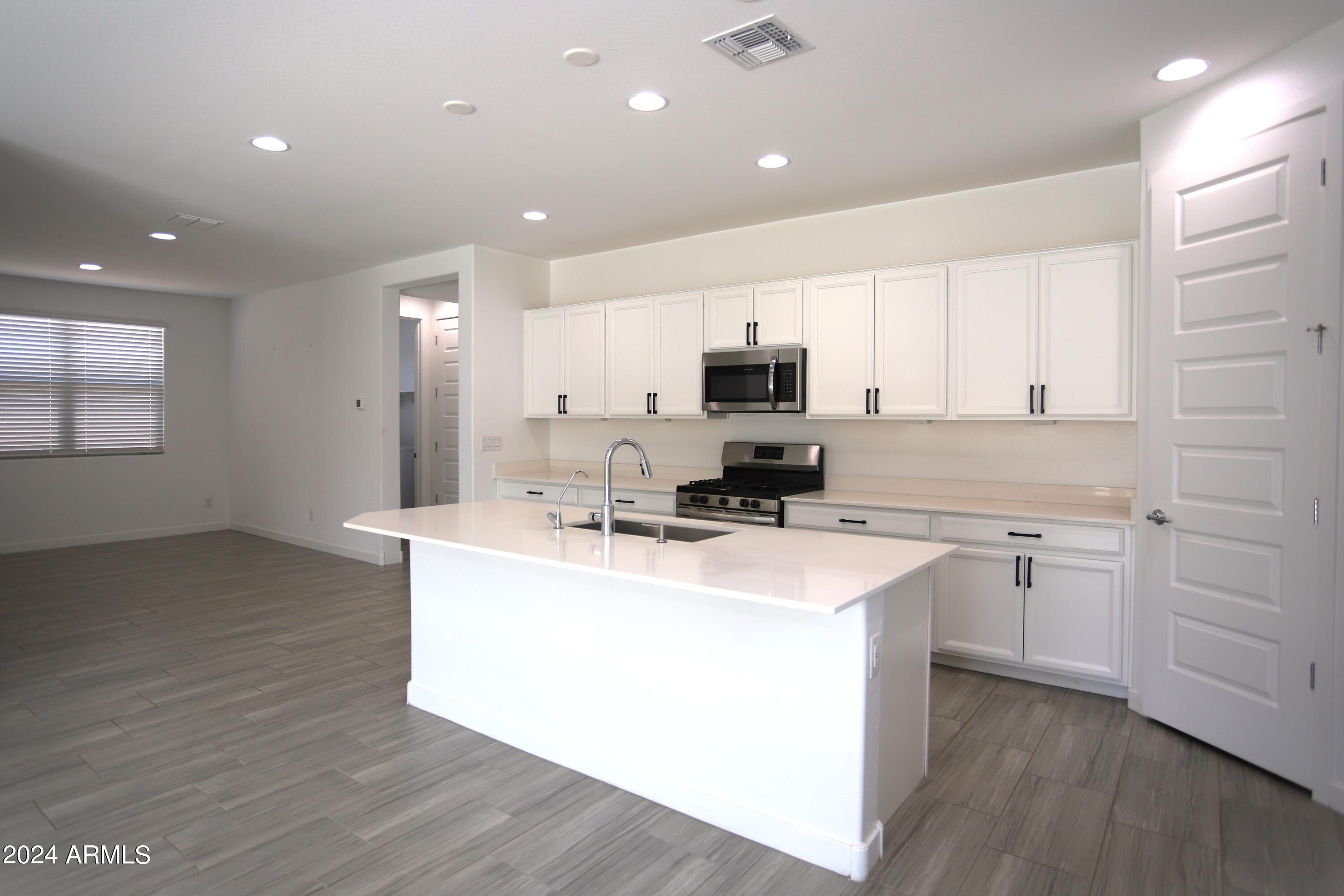1651 West Piedmont Road Phoenix, AZ 85041 - Photo 22 of 46 a kitchen with appliances a sink a counter space and cabinets