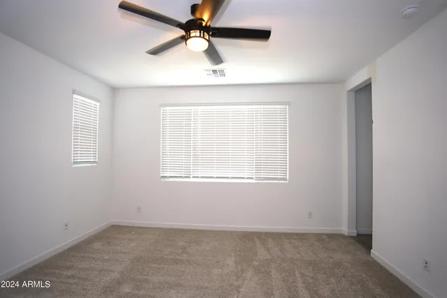 an empty room with a window and a fan