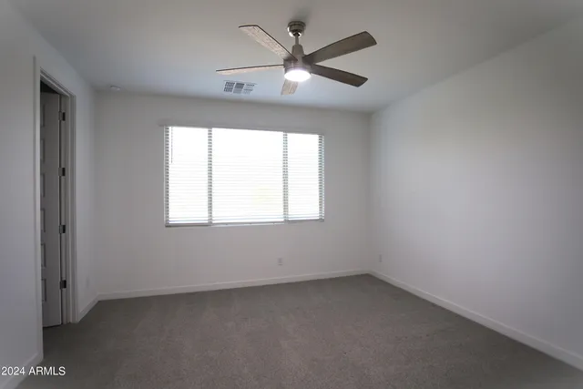 an empty room with a window and a fan