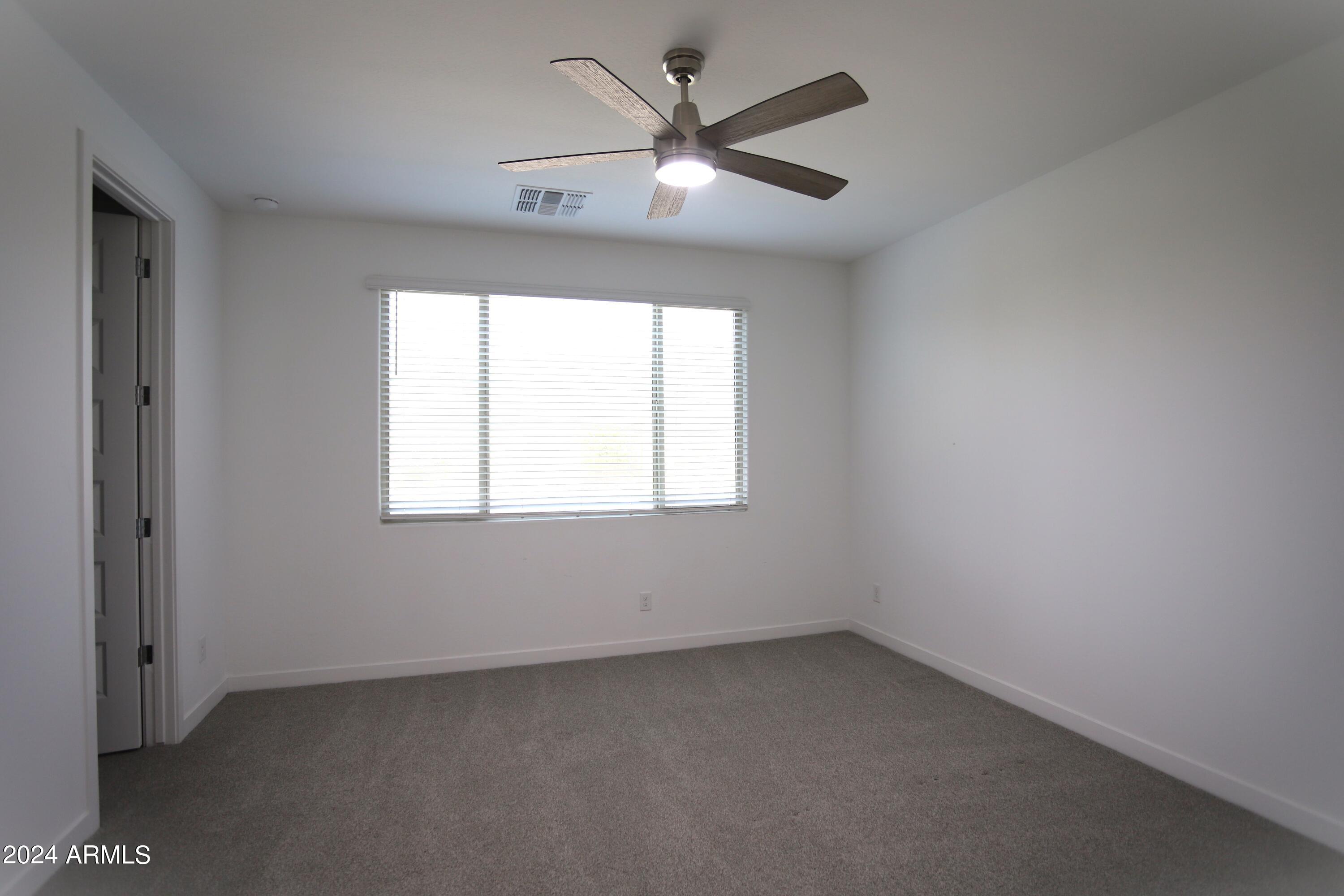 1651 West Piedmont Road Phoenix, AZ 85041 - Photo 28 of 46 an empty room with a window and a fan