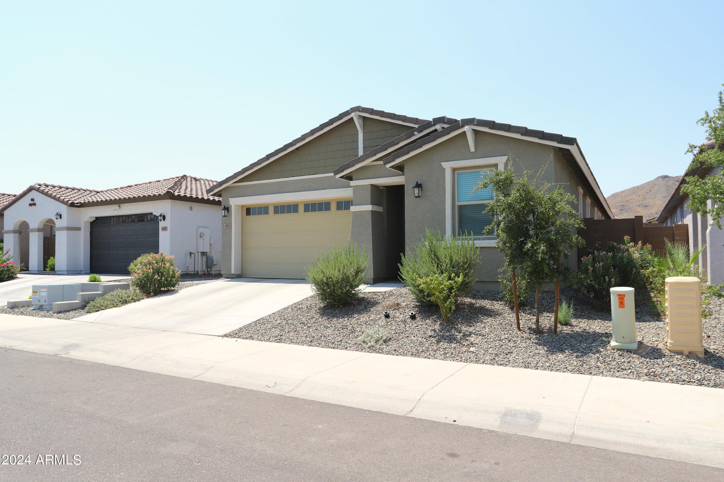 1651 West Piedmont Road Phoenix, AZ 85041 - Photo 3 of 46 a front view of a house with garden and plants