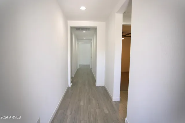 a view of a hallway with wooden floor
