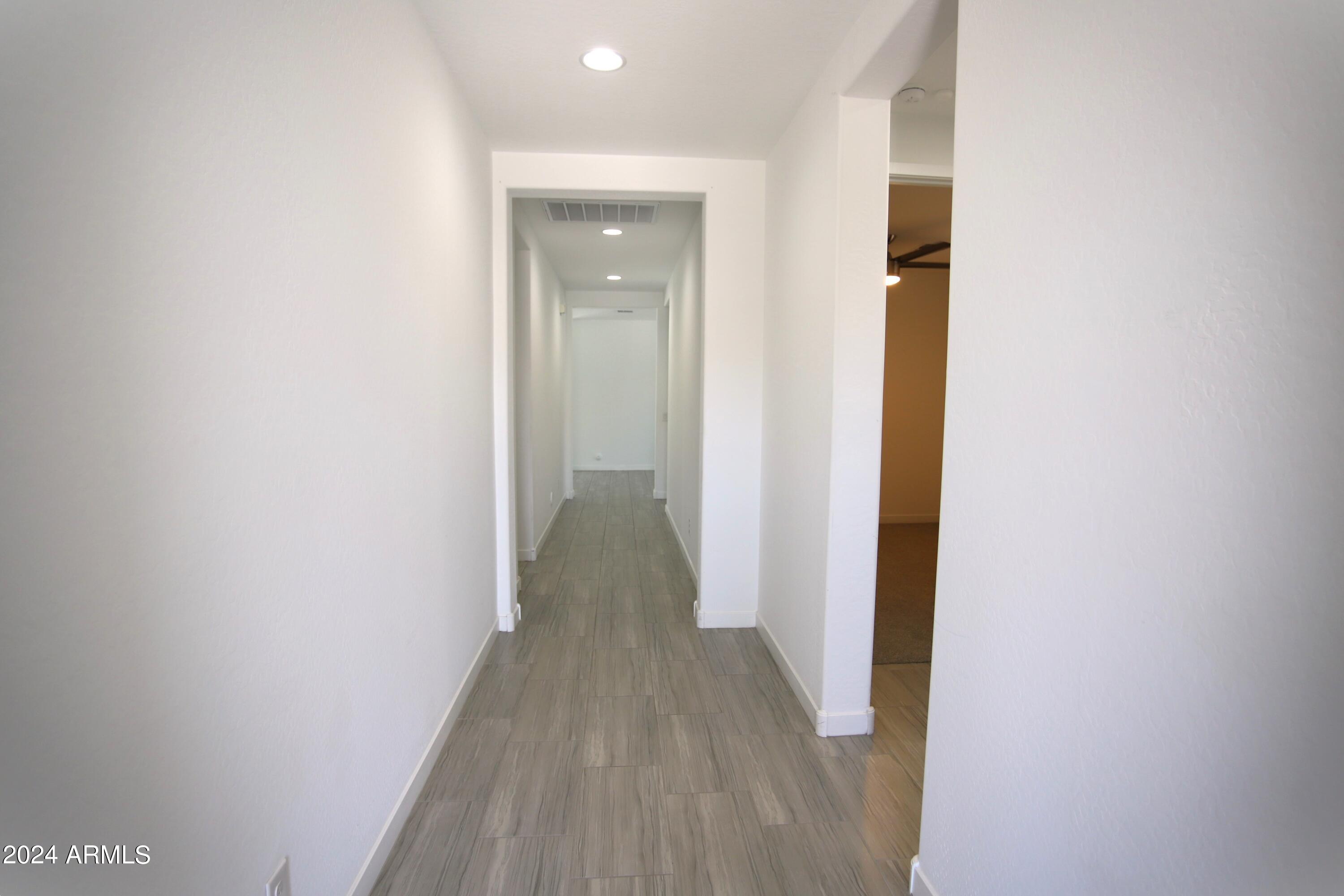 1651 West Piedmont Road Phoenix, AZ 85041 - Photo 6 of 46 a view of a hallway with wooden floor