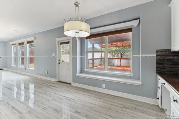 a view of an empty room with a window and wooden floor