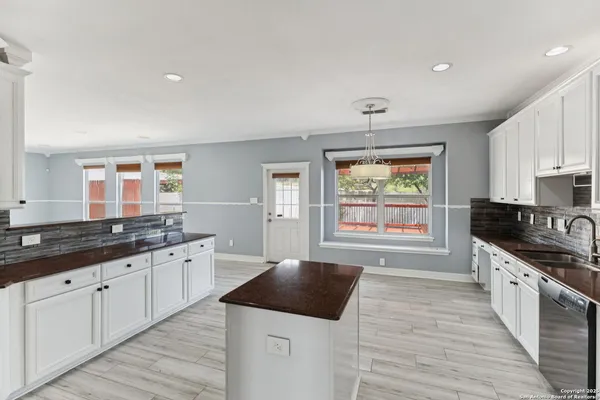a kitchen with granite countertop a stove a sink and a refrigerator