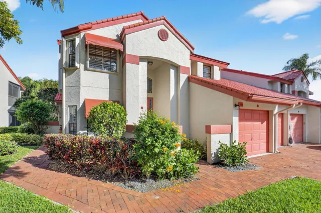 a view of a house with a yard and potted plants