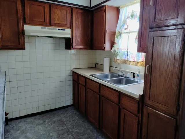 a bathroom with a granite countertop toilet sink and mirror