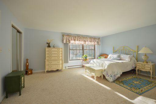 195 Falmouth Road, Unit 14C Mashpee, MA 02649 - Photo 15 of 27 a bed sitting in a spacious bedroom next to a window